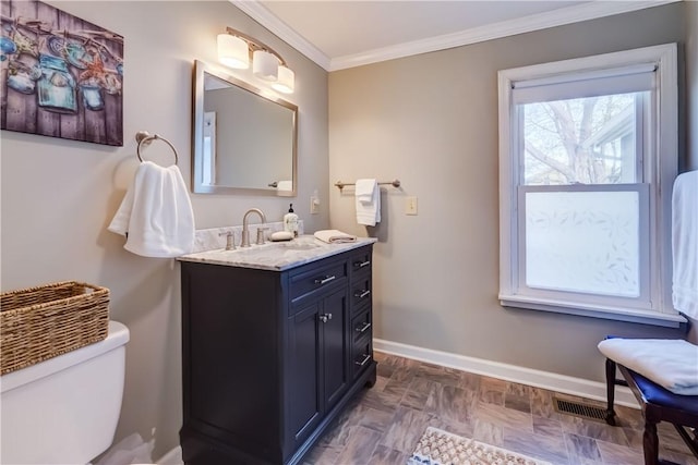 bathroom featuring vanity, toilet, baseboards, visible vents, and ornamental molding