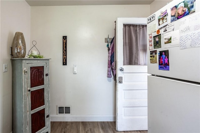 doorway to outside featuring visible vents, baseboards, and wood finished floors