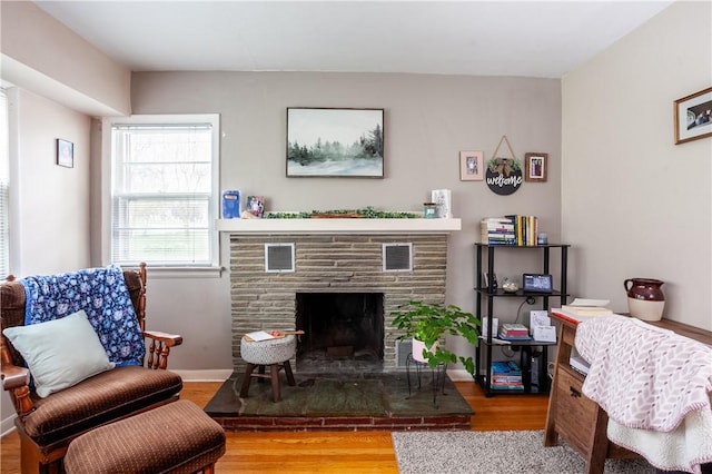interior space featuring visible vents, wood finished floors, and a fireplace