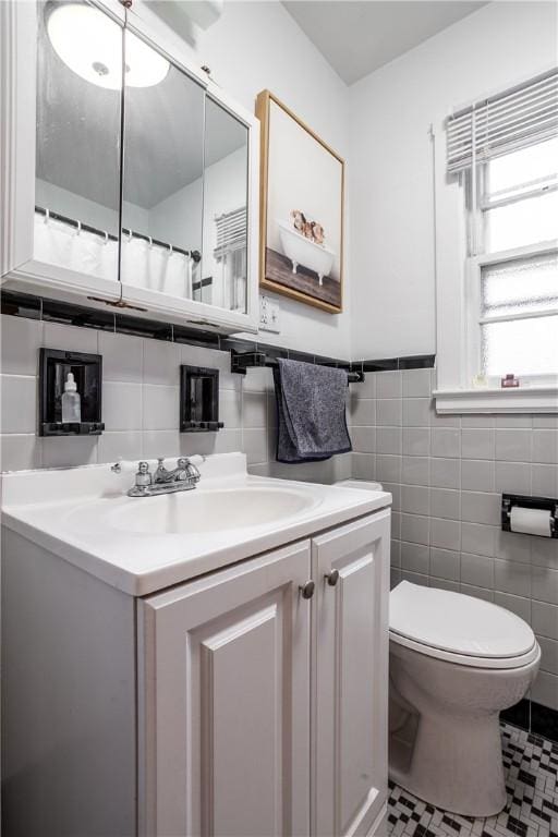full bath with wainscoting, tile walls, vanity, and toilet
