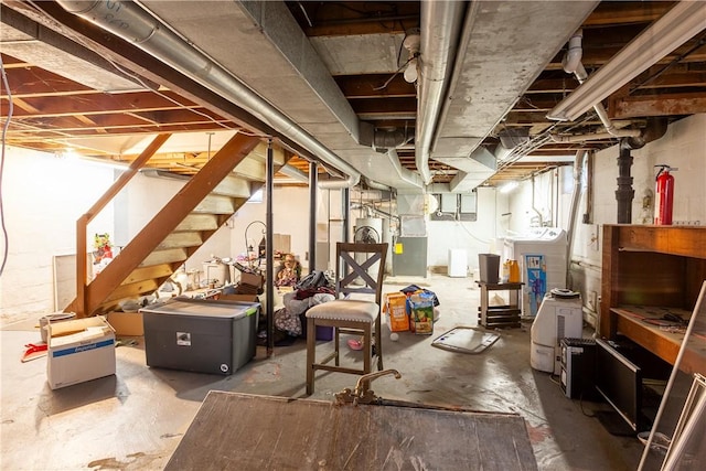 below grade area with stairway, heating unit, and washing machine and dryer
