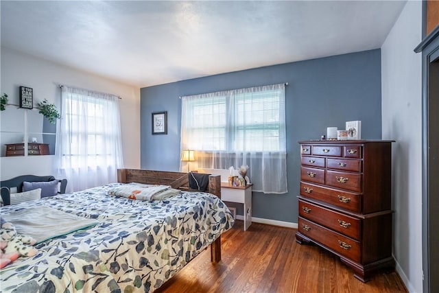bedroom featuring baseboards and dark wood finished floors