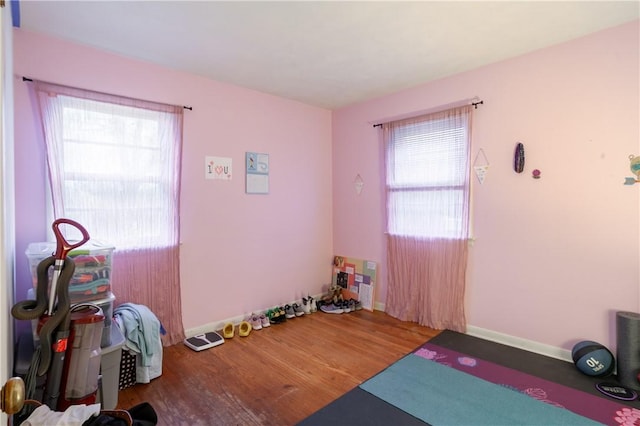workout area featuring baseboards and wood finished floors