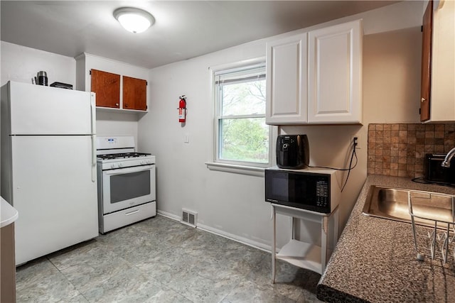 kitchen featuring visible vents, backsplash, white cabinets, and white appliances