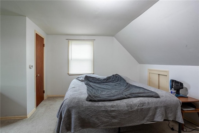 carpeted bedroom with baseboards and lofted ceiling