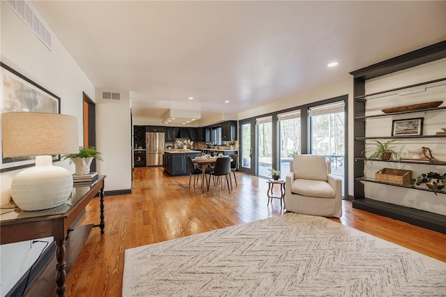 living room featuring visible vents and light wood-type flooring