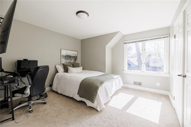 bedroom with baseboards, light carpet, and visible vents