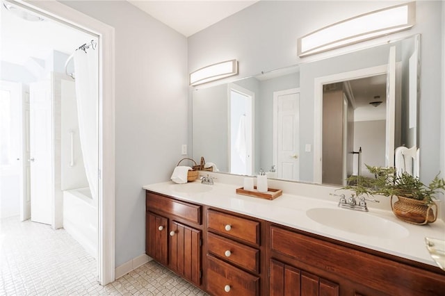 bathroom featuring double vanity, washtub / shower combination, and a sink