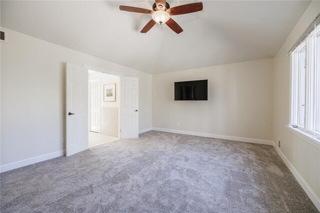 carpeted spare room featuring baseboards, a ceiling fan, and vaulted ceiling
