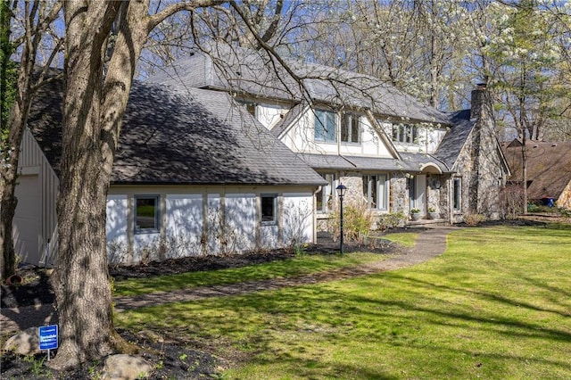 view of front facade featuring a chimney and a front lawn
