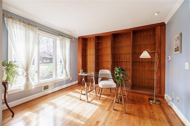 living area featuring crown molding, baseboards, wood finished floors, and visible vents