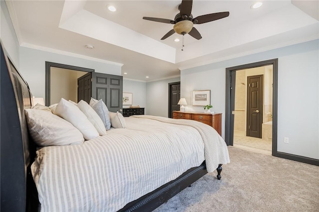 bedroom featuring ensuite bathroom, a tray ceiling, recessed lighting, and light colored carpet