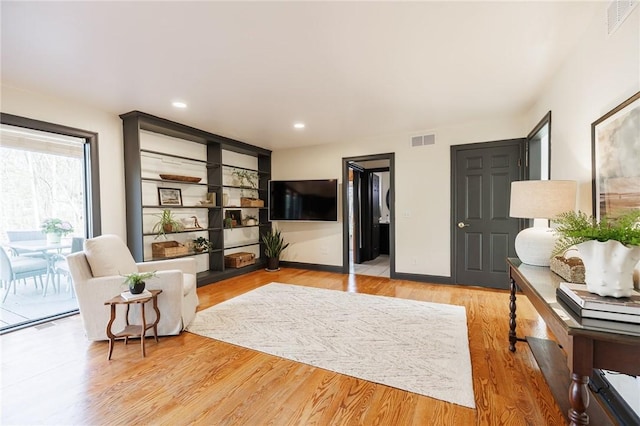 living area featuring recessed lighting, baseboards, light wood finished floors, and visible vents