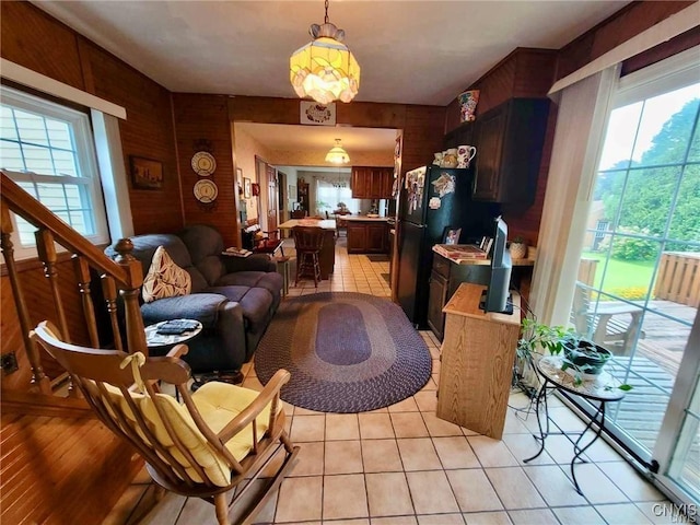 living area with wood walls, plenty of natural light, and light tile patterned floors
