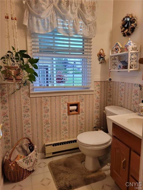 half bath with a wealth of natural light, baseboard heating, and tile patterned flooring
