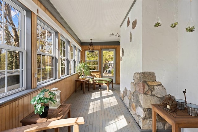 sunroom / solarium featuring wood walls and hardwood / wood-style flooring