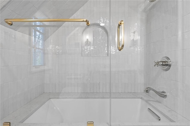 bathroom with bath / shower combo with glass door