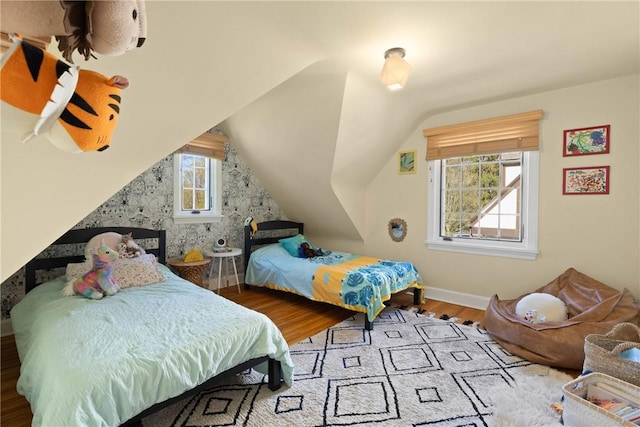 bedroom featuring baseboards, lofted ceiling, and wood finished floors