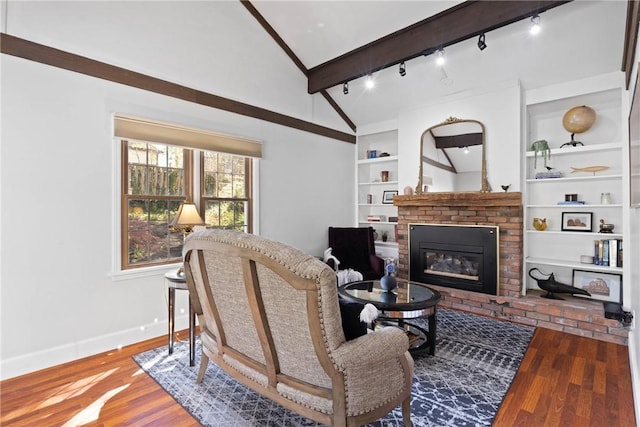 living room with lofted ceiling with beams, a brick fireplace, built in features, baseboards, and wood finished floors