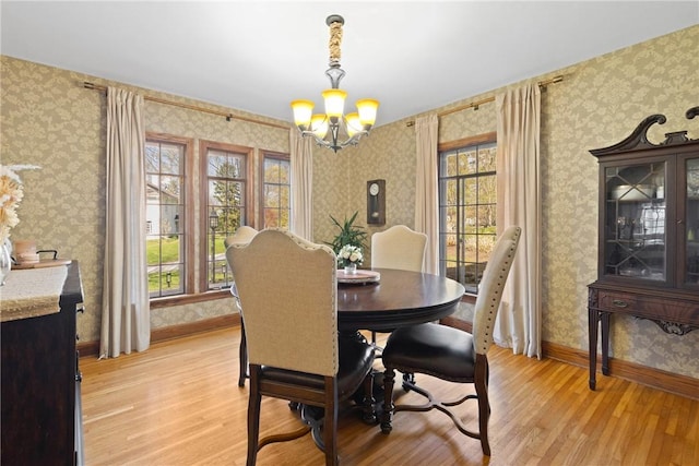 dining area featuring wallpapered walls, a notable chandelier, a wealth of natural light, and light wood-style floors