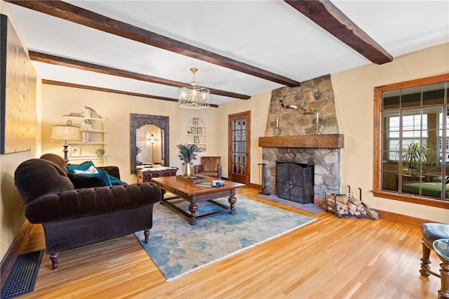living area featuring baseboards, beamed ceiling, a notable chandelier, and wood finished floors