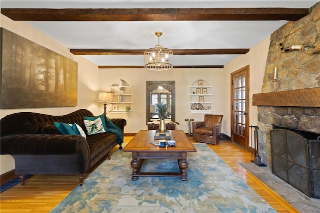 living room featuring baseboards, a stone fireplace, wood finished floors, and beam ceiling