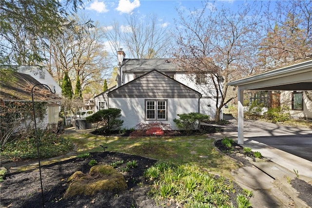 view of side of property featuring a chimney and stucco siding