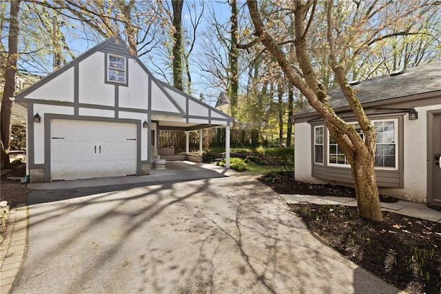 view of front of house with an outdoor structure, a garage, aphalt driveway, and stucco siding
