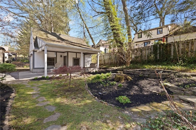 view of yard featuring fence and covered porch
