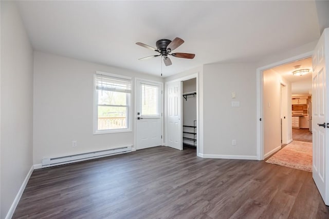 unfurnished bedroom featuring a ceiling fan, dark wood finished floors, baseboards, a closet, and a baseboard heating unit