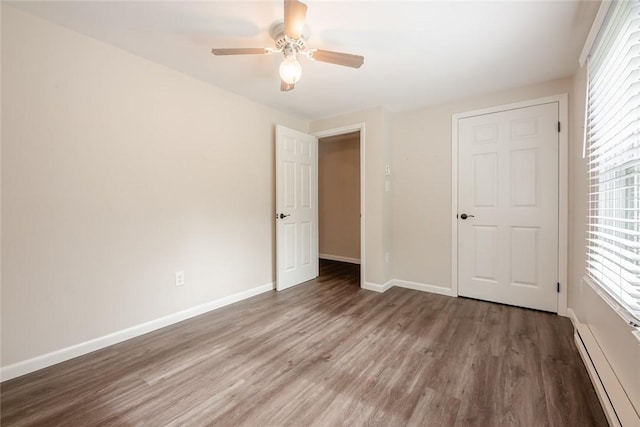 unfurnished bedroom with baseboards, a baseboard radiator, ceiling fan, and wood finished floors