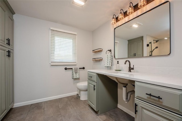 full bathroom featuring toilet, baseboards, walk in shower, tile patterned floors, and a sink