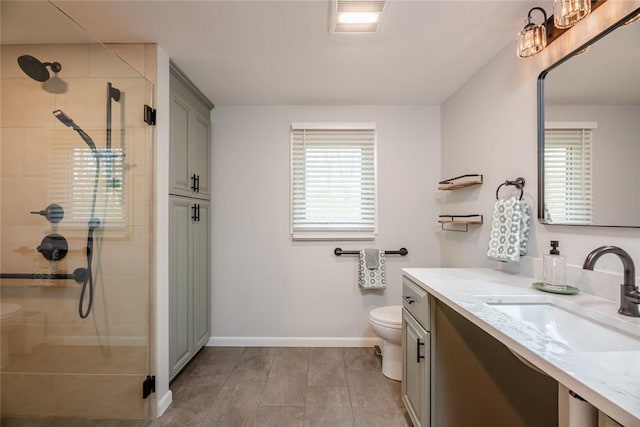 full bath featuring toilet, baseboards, a shower stall, and vanity