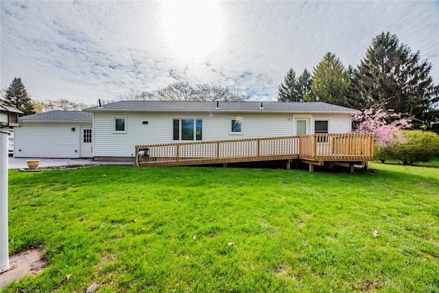 rear view of property featuring a yard and a wooden deck