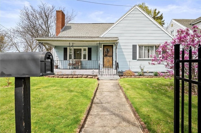 bungalow-style home with covered porch, a chimney, and a front lawn
