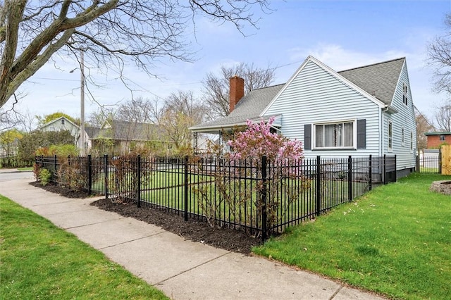 view of side of home featuring a shingled roof, a chimney, a yard, and fence private yard