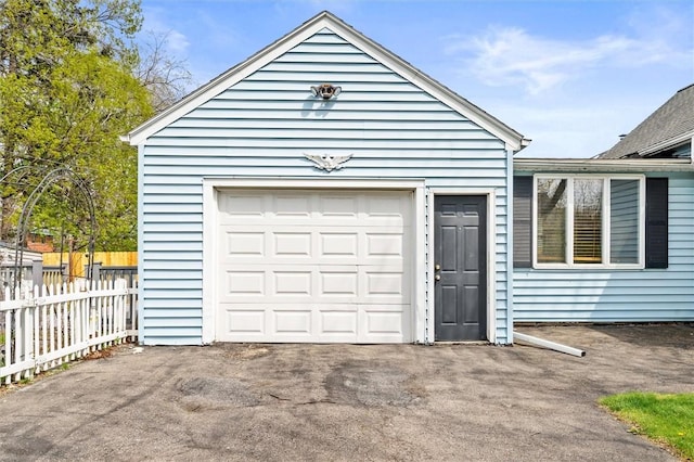 garage with fence and driveway