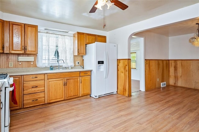 kitchen with ceiling fan, a sink, white appliances, a wainscoted wall, and visible vents