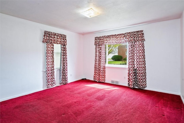 unfurnished room featuring carpet floors, baseboards, and visible vents