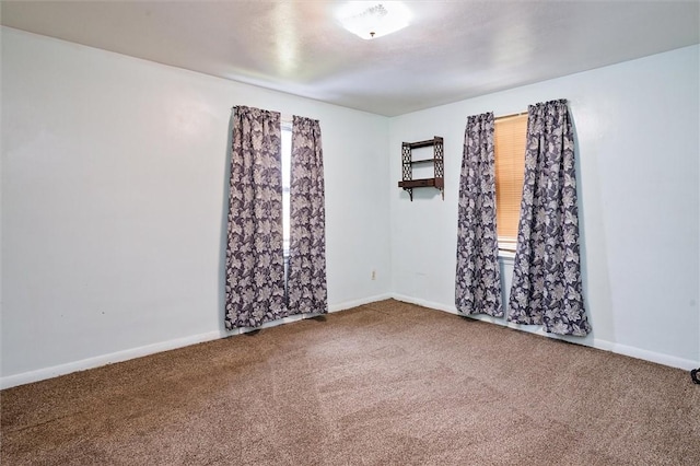carpeted spare room featuring baseboards