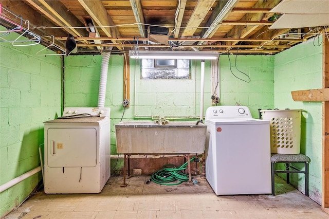 clothes washing area featuring a sink, laundry area, and washing machine and clothes dryer