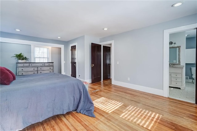 bedroom featuring baseboards, recessed lighting, wood finished floors, and a closet