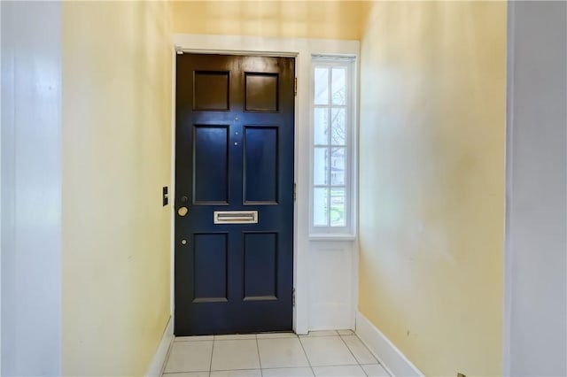 foyer entrance featuring light tile patterned flooring and baseboards