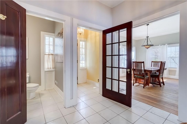 entryway with baseboards and light tile patterned floors