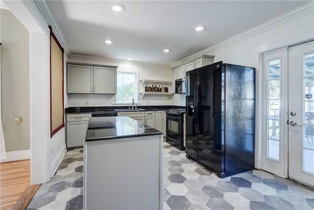 kitchen featuring crown molding, open shelves, a kitchen island, dark countertops, and black appliances
