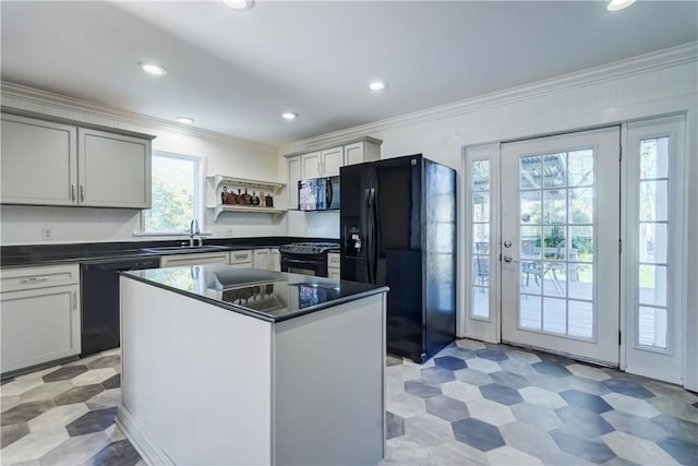 kitchen featuring crown molding, dark countertops, open shelves, a sink, and black appliances
