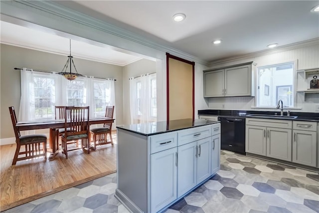 kitchen featuring black dishwasher, dark countertops, plenty of natural light, and a sink