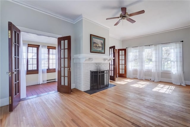 unfurnished living room with baseboards, ornamental molding, french doors, and light wood finished floors
