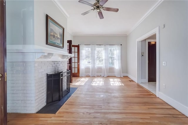 unfurnished living room featuring a ceiling fan, light wood-type flooring, ornamental molding, and a fireplace