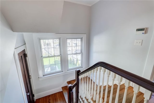 staircase featuring baseboards and wood finished floors